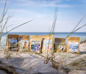 Paczki Kawy Kołobrzeskiej na plaży w Kołobrzegu.