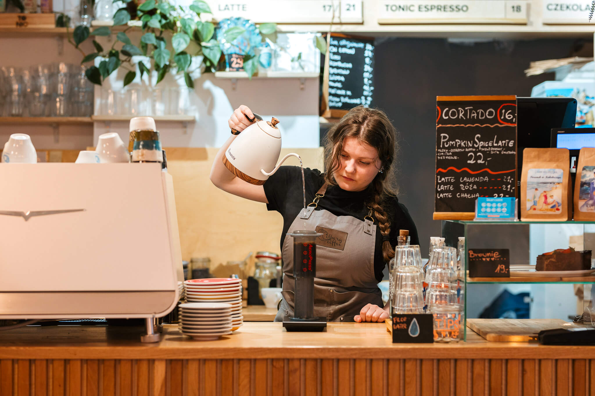 Baristka parzy najlepszą lokalną kawę w kawiarni Kołobrzeskiej Colbergcoffee