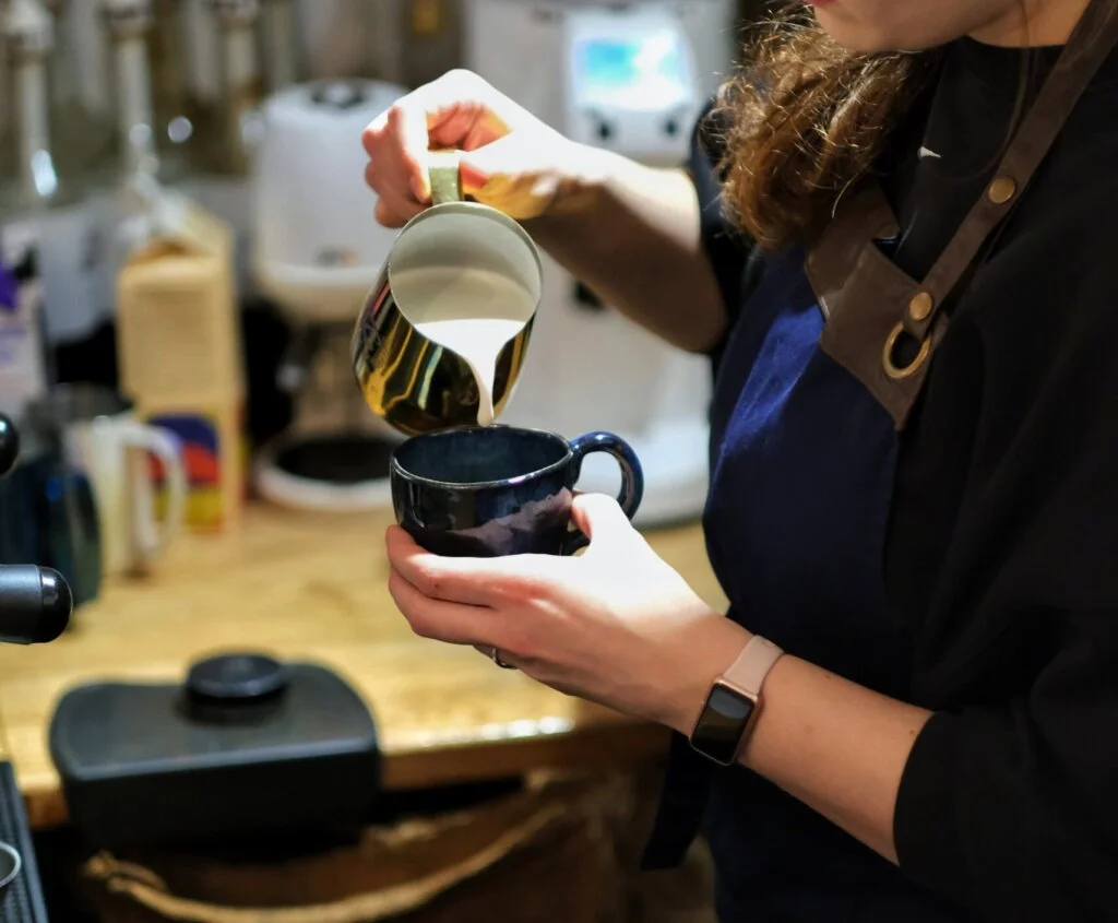 Wlewanie spienionego mleka do espresso, flat white