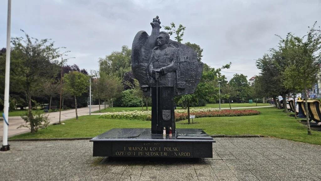 Pomnik Józefa Piłsudskiego w Kołobrzegu Pomnik odsłonięto w 1999 roku, a pod nim znajduje się kamień węgielny z datą 11 listopada. Piłsudski stoi tutaj dumnie, z orłem w tle, jakby pilnował nie tylko historii, ale i całego parku