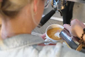 baristka przygotowuje latte art