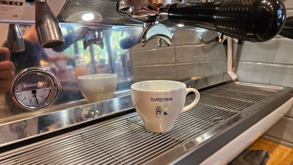 Filiżanka z logo Syrenka pod grupą ekspresu Nuova Simonelli Appia Life XT