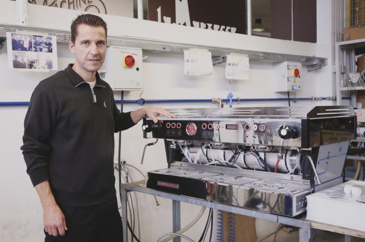 Pracownik La Marzocco przy trzygrupowym ekspresie na stanowisku w fabryce