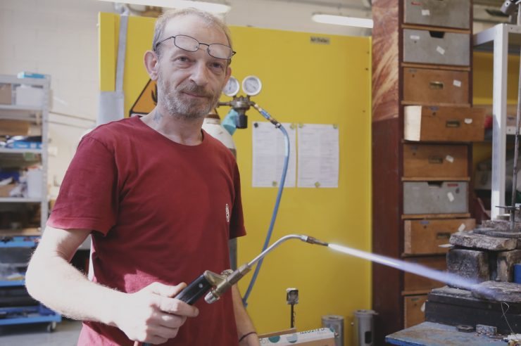 Pracownik fabryki La Marzocco z palnikiem do lutowania