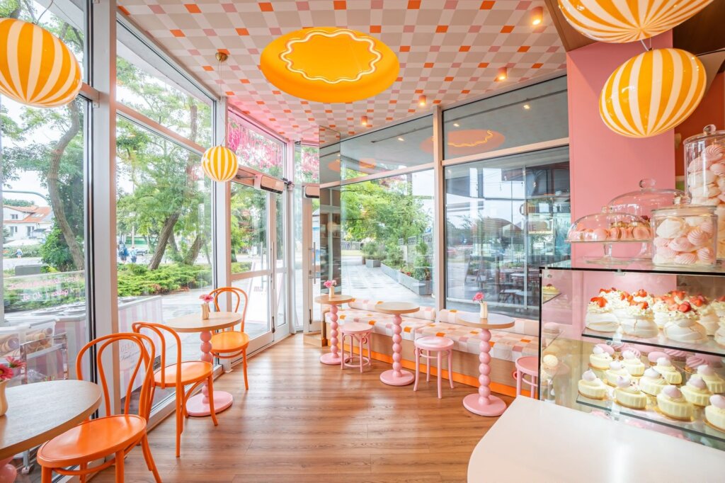 Pink tables and orange chairs by the windows at Ma Ma Cafe in Swinoujscie
