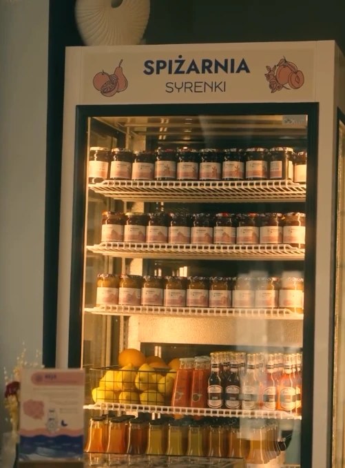 Spiżarnia Syrenki: lodówka z przetworami w słoikach i sokami Kołobrzeski Sad